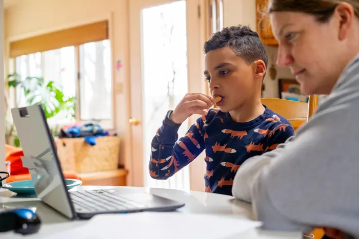 On the afternoon of 20 March 2020 in Connecticut, United States of America, Luka, 8, has a snack while working on a school assignment as part of his second grade class&rsquo;s distance learning measures. Local schools were closed indefinitely effective 13 March