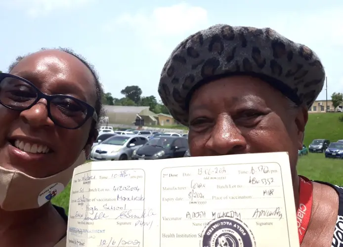 Gail Hoad of UNICEF Jamaica, left, with her mum holding her vaccination card on COVID-19 vaccination day in Manchester parish, Jamaica, June 13, 2021.