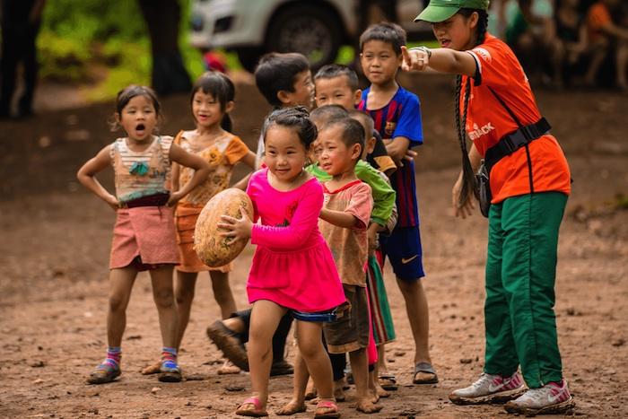 A coach teaches kids teamwork through sport in a village in Laos.