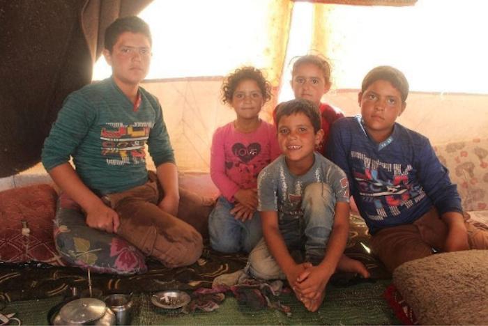 Hasan, 8, front and center, and his four siblings live in a camp for displaced persons in northern Idlib, Syria, where they have access to a self-learning program supported by UNICEF.