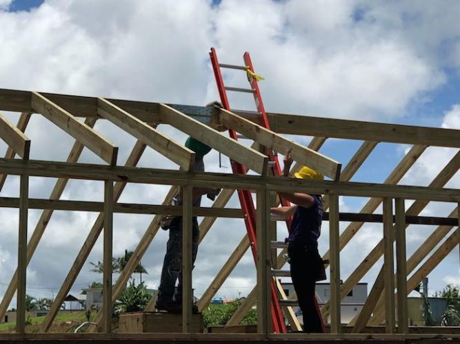 Student volunteers and skilled carpenters work together to repair roofs in Puerto Rico.