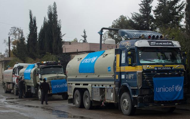 UNICEF-supported trucks queue to fill their tanks with water from a group of wells rehabilitated and equipped by UNICEF