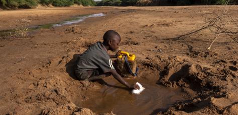 A young boy collects what little water he can from a dried up riverbed in Dollow Somalia, where severe drought has taken hold..