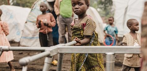 A little girl draws water at the Kizimba site for displaced people in Sake, North Kivu province, DRC. The standpipe was installed with UNICEF support.