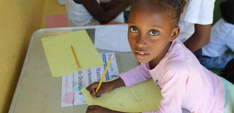 Seven-year-old Lovenska of Haiti works on a drawing at a UNICEF-supported child-friendly space in Delmas 6, downtown Port-au-Prince.