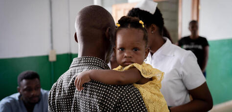 A child hugs her father in the vaccination ward of the Justinien hospital in Cap-Haitien.
