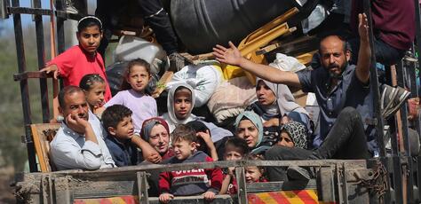 Children with their families sitting in the back of a truck during their displacement from areas witnessing an escalation in hostilities in Rafah, south of the Gaza Strip.