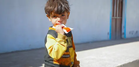 A malnourished child eats Ready-to-Use Therapeutic Food after being screened and diagnosed at the UNICEF-supported mobile clinic in Dhamar, Yemen.