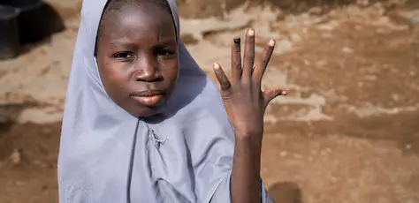 A 12-year-old girl in Katsina, Nigeria, shows her nail marked with ink indicating that she has been vaccinated against the human papillomavirus (HPV).