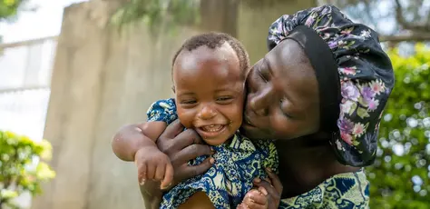 After feeding, a mother plays with her baby at a UNICEF nutrition event in Uganda on April 23, 2025.