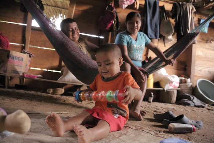 On 15 August 2016 in Belize, Abner Choc, 2, sitting on an old mat on the dirt floor, plays with a toy at home, in San Felipe Village in the Toledo region.