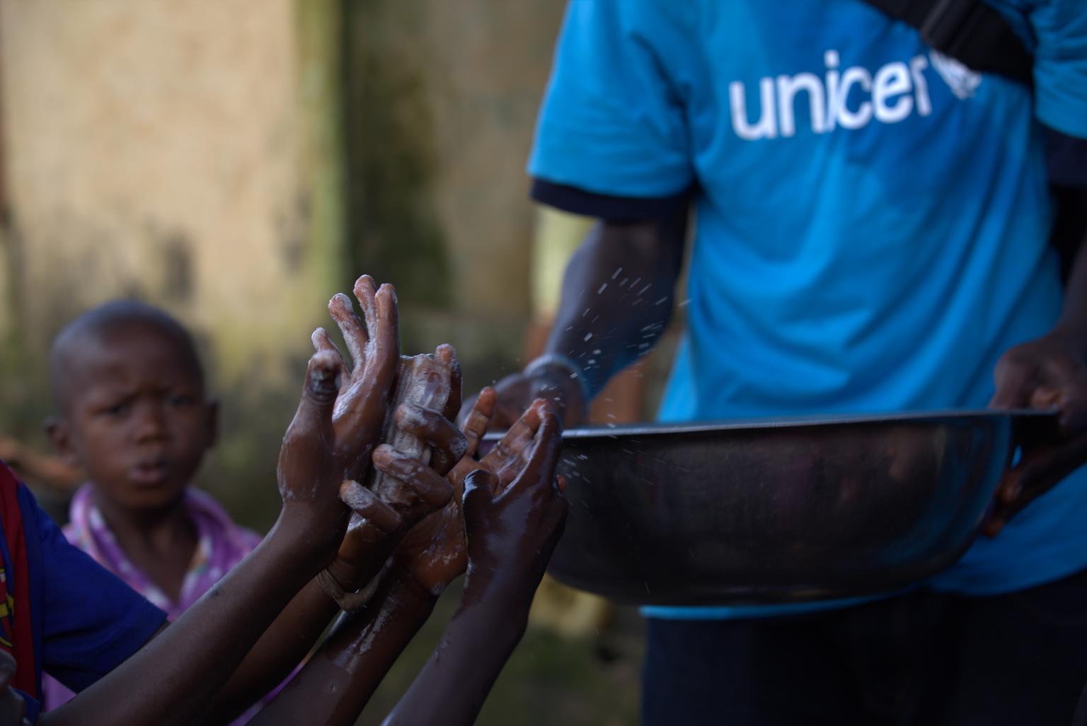 A social mobilizer teaches children about proper hand-washing in Conakry. 