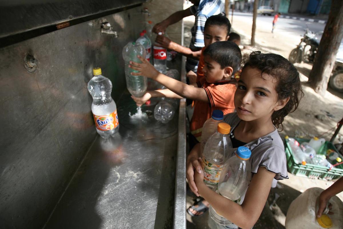 Children gather water from a Gaza tap.