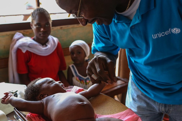 Souleymane Diabaté, UNICEF Representative in the Central African Republic, visits an infant during a 2013 vaccination campaign